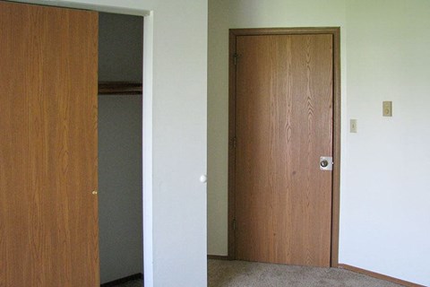 an empty room with a door and a closet