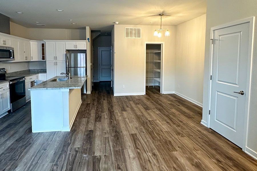 A kitchen with a white island and wooden floors.