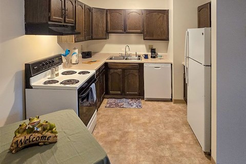 A kitchen with a white stove and a white refrigerator.