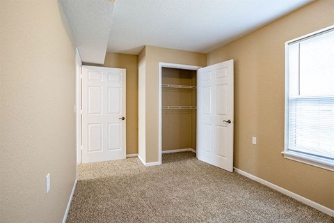 an empty room with two doors and a closet