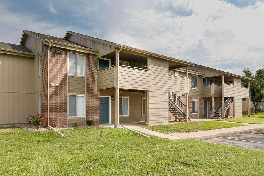 a row of apartment buildings with stairs and grass
