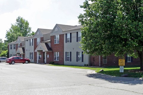 A red car is parked in front of a building with a sign that says "SPEED AWAY".