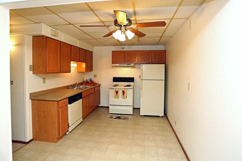 A kitchen with white appliances and wooden cabinets.