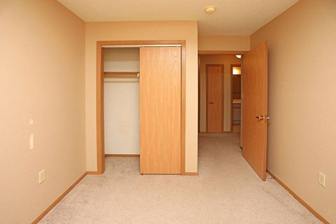 A hallway with a carpeted floor and two doors.