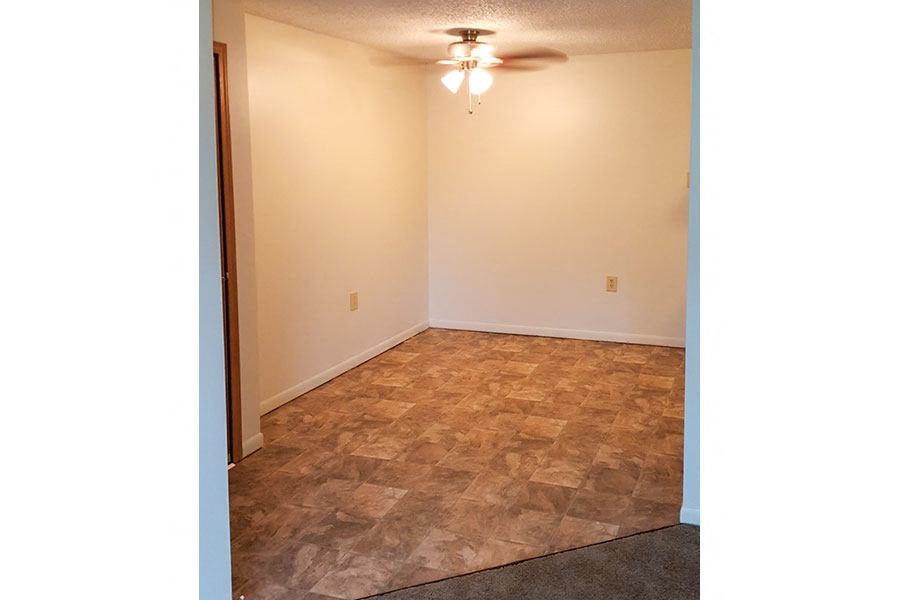 A room with a ceiling fan and a carpeted floor.