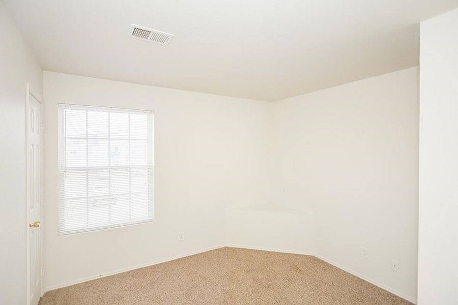 A room with a window and carpeted floor.