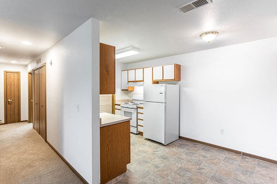 A kitchen area with a white refrigerator and a white stove top oven.