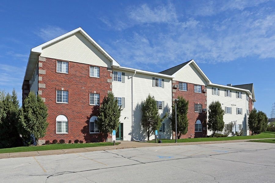a brick apartment building with white siding