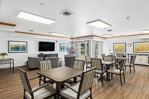 A dining room with a large table and chairs.