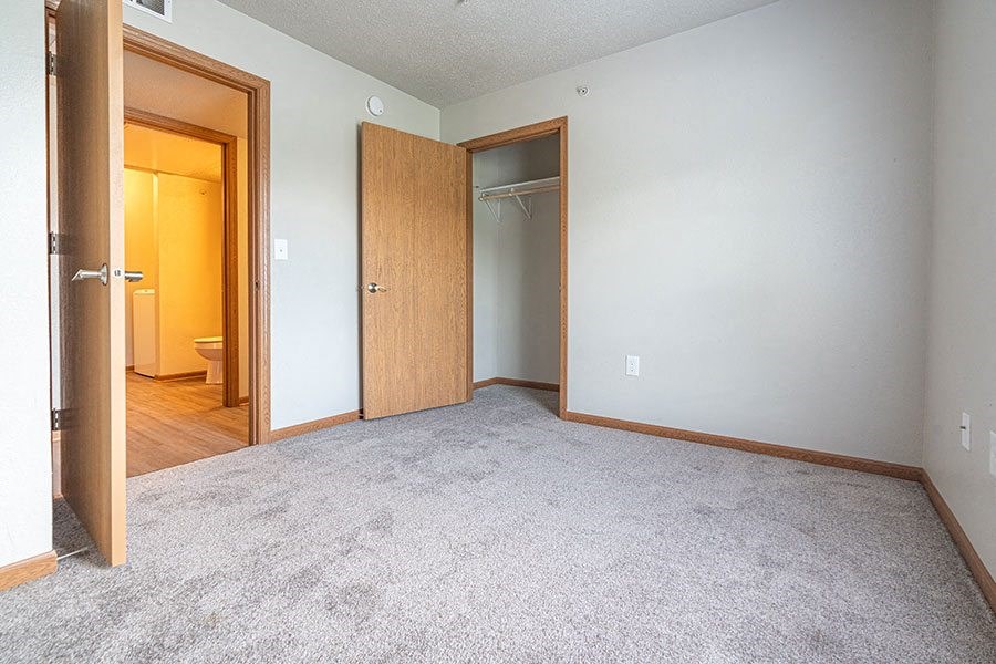 an empty room with a closet and a door to a bathroom