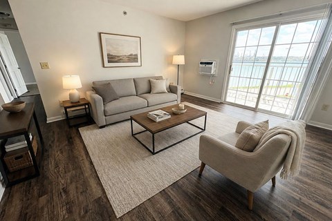 A living room with a grey couch, a coffee table, and a chair.