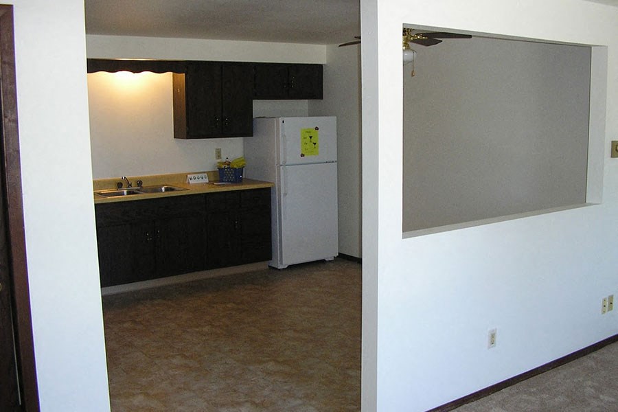 an empty kitchen with a refrigerator and a sink