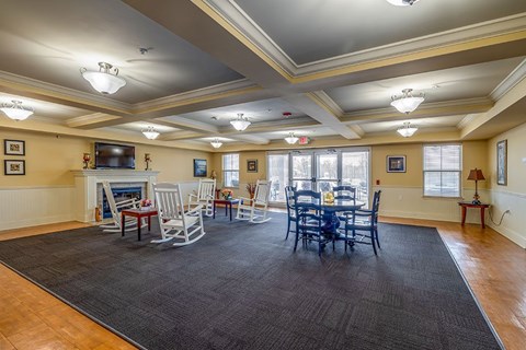 A spacious living room with a fireplace and a dining table set up.