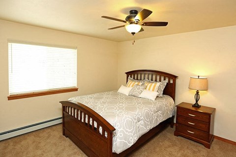 a bedroom with a bed and a ceiling fan