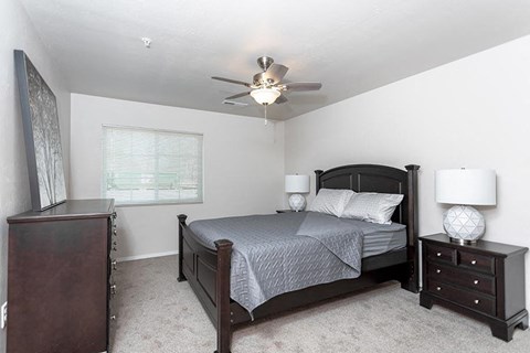 a bedroom with a bed and a ceiling fan