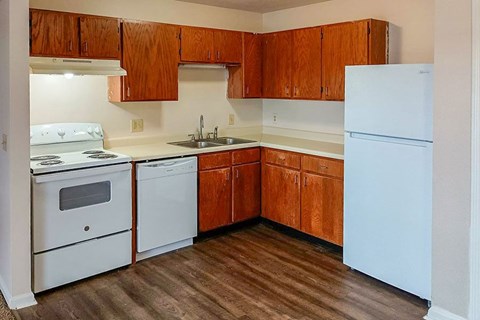 A kitchen with wooden cabinets and white appliances.