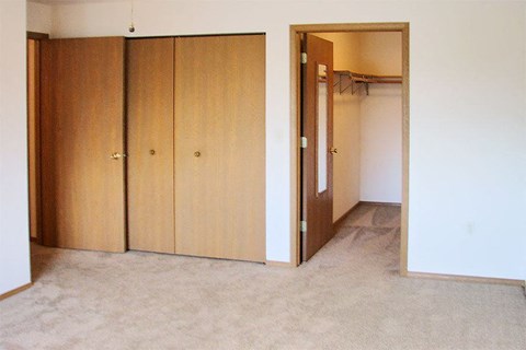 an empty room with a closet and an open door