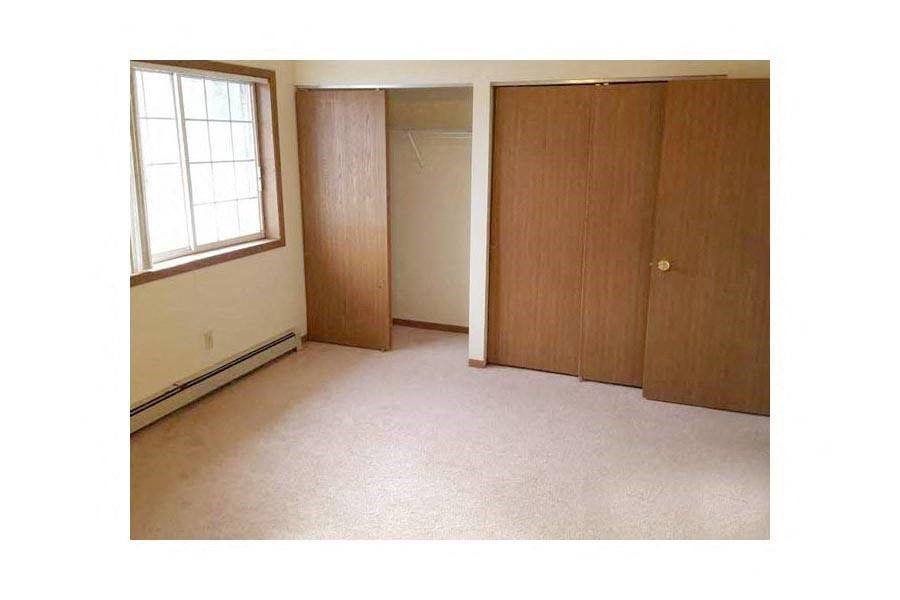 a bedroom with a closet and a window