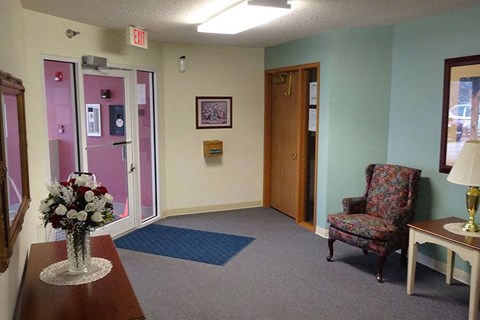 a lobby with a chair and a vase of flowers