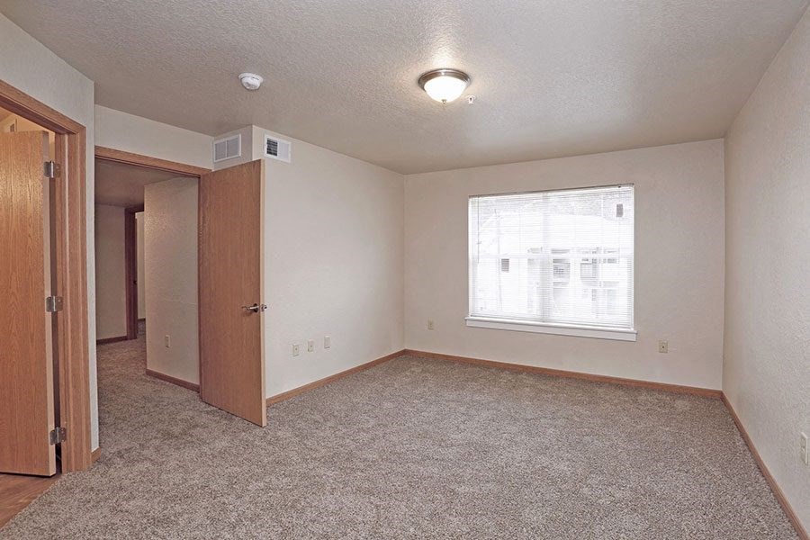 an empty room with a window and a door