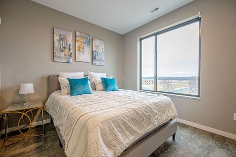 A bedroom with a large bed and a view of the outside.