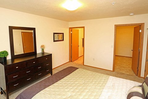 a bedroom with a bed and a dresser and a mirror