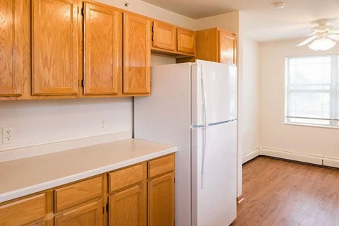 A kitchen with wooden cabinets and a white refrigerator.