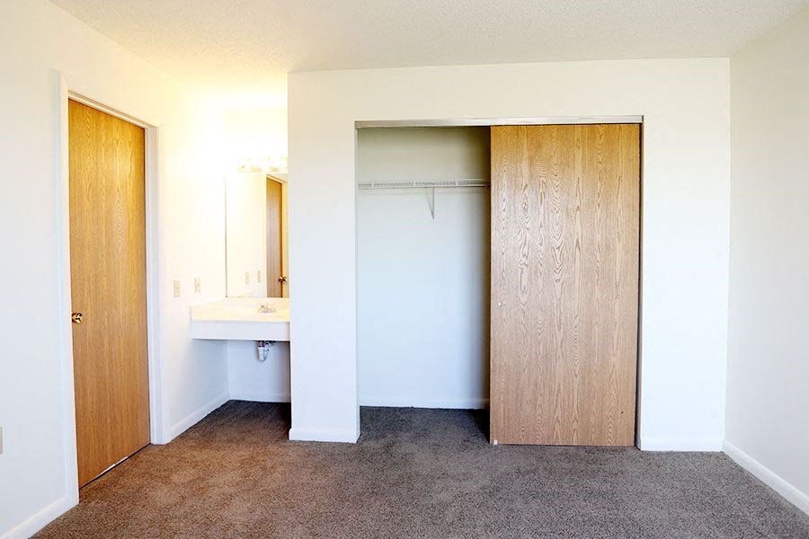 an empty room with a closet and a sink
