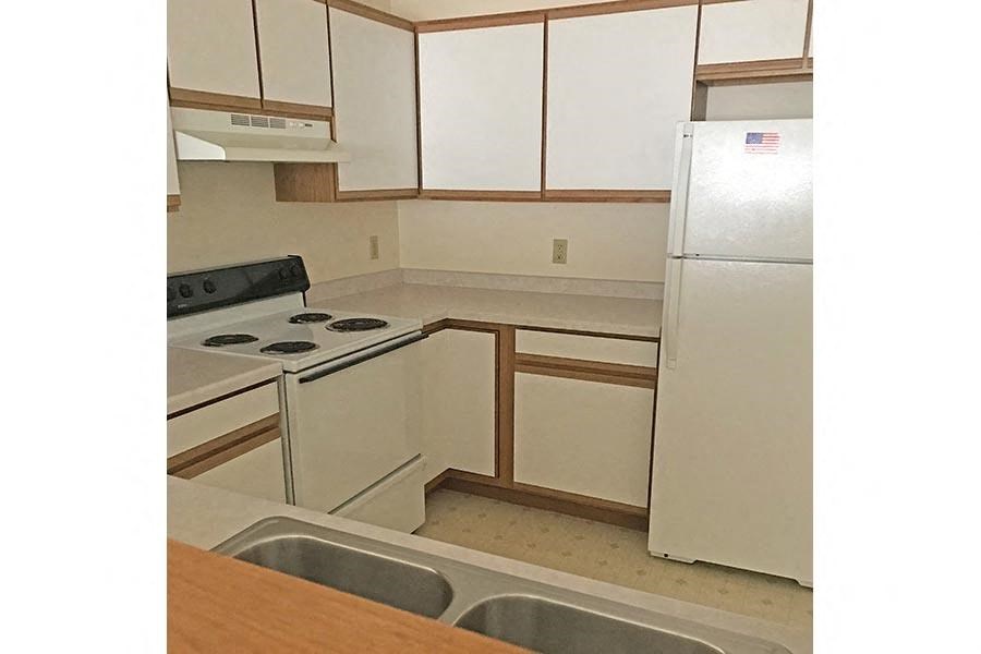 an empty kitchen with a stove and a refrigerator