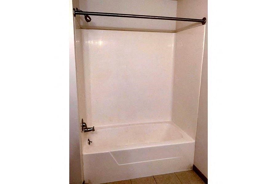 a white bathroom with a tub and a shower curtain