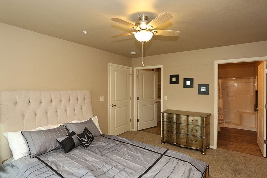 a bedroom with a large bed and a ceiling fan