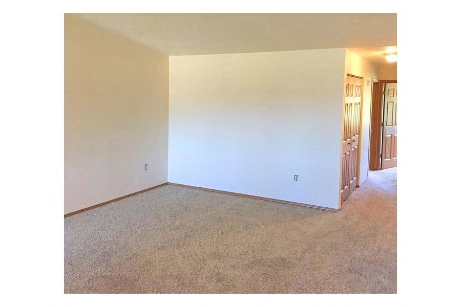an empty living room with a white wall
