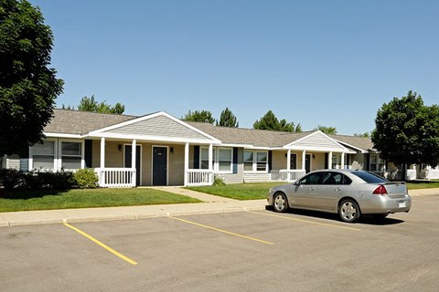 a silver car parked in front of an empty parking lot