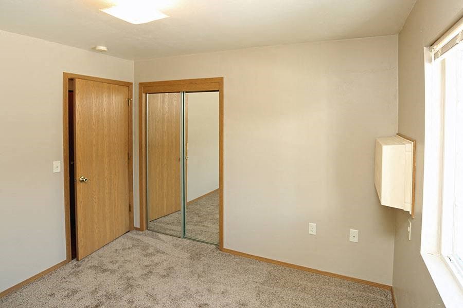 an empty room with a mirror and a closet