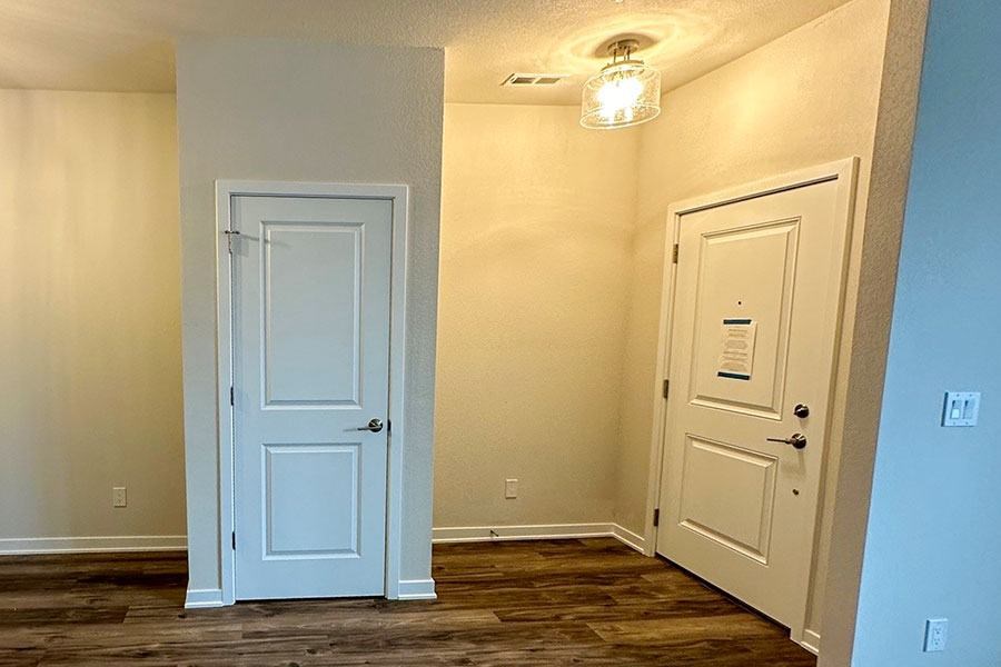 A white door is on the left and a white door with a sign on it is on the right.
