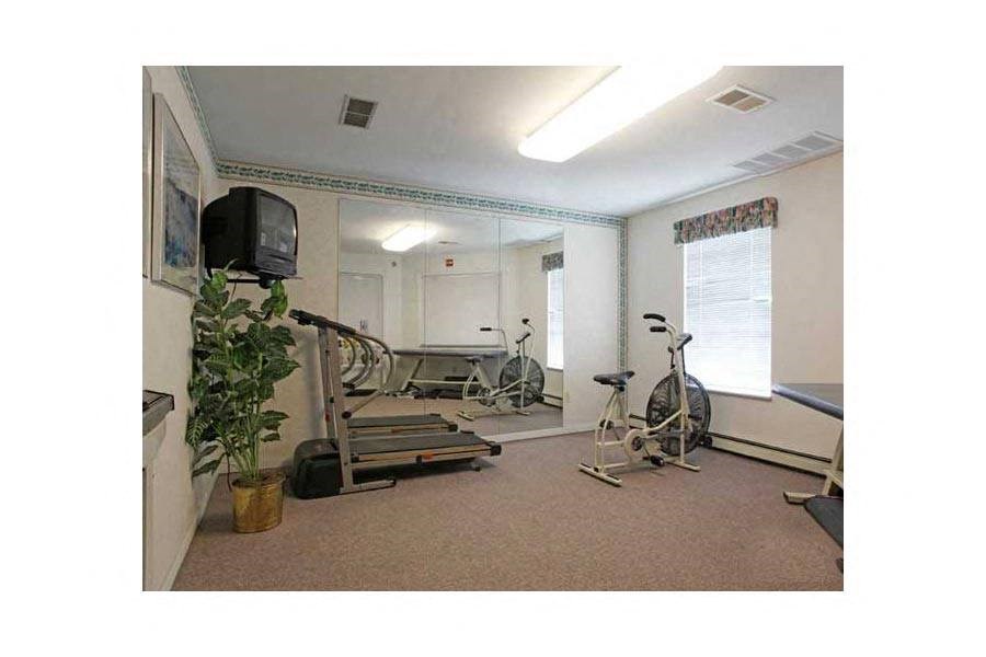 a home gym with exercise equipment and a tv