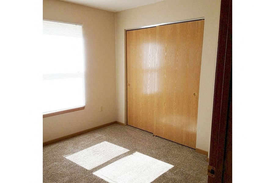 A room with a brown door and a carpet on the floor.