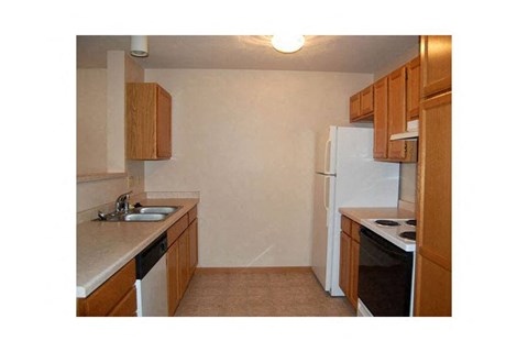 A kitchen with a white fridge, black stove, and brown cabinets.