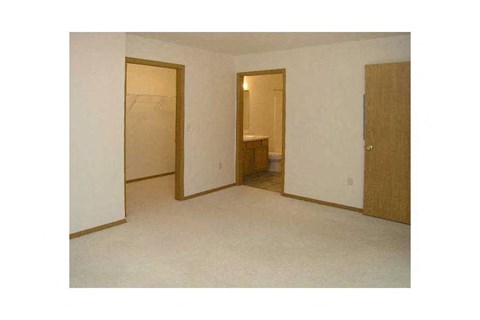A room with a white wall and a brown door.