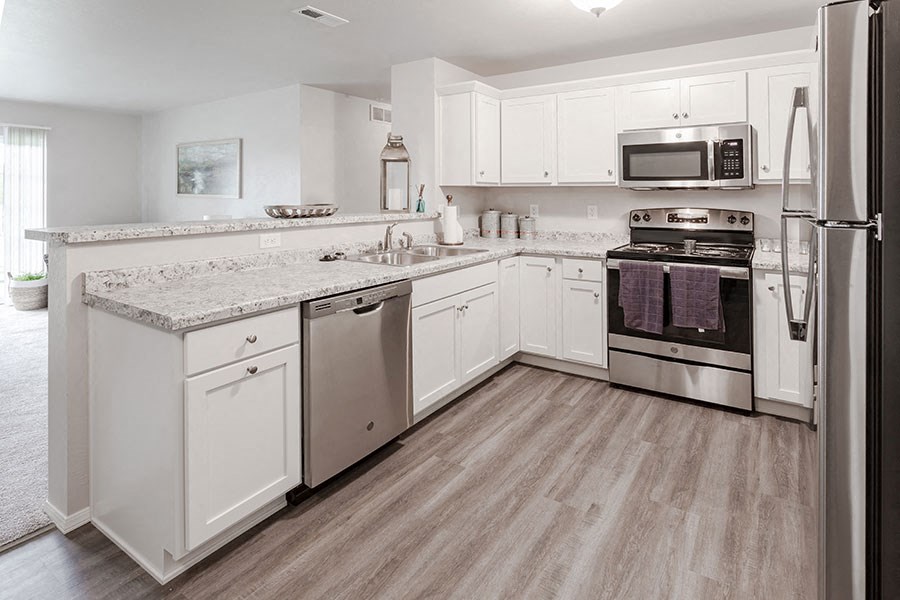 a kitchen with white cabinets and stainless steel appliances
