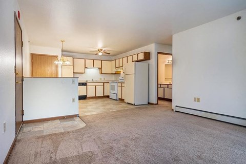 A kitchen with white appliances and wooden cabinets.