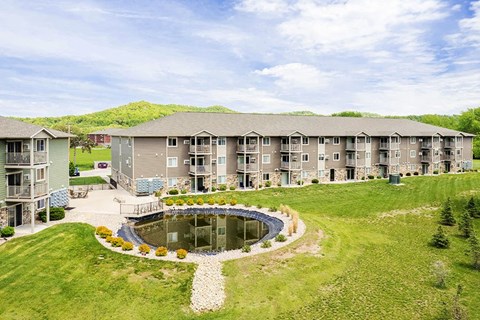 an aerial view of an apartment building with a pond