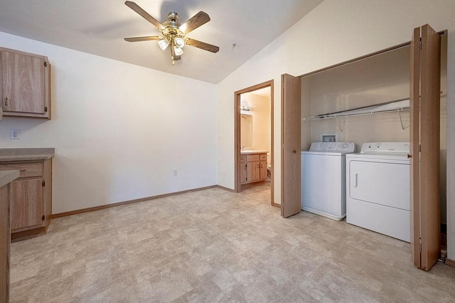 A room with a ceiling fan and a washer and dryer.
