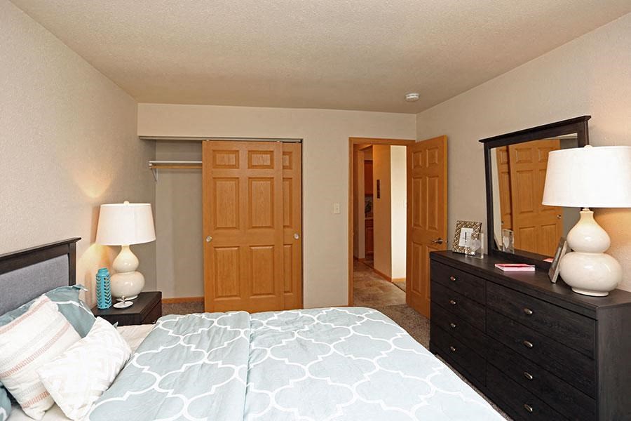 a bedroom with a large bed and a mirror