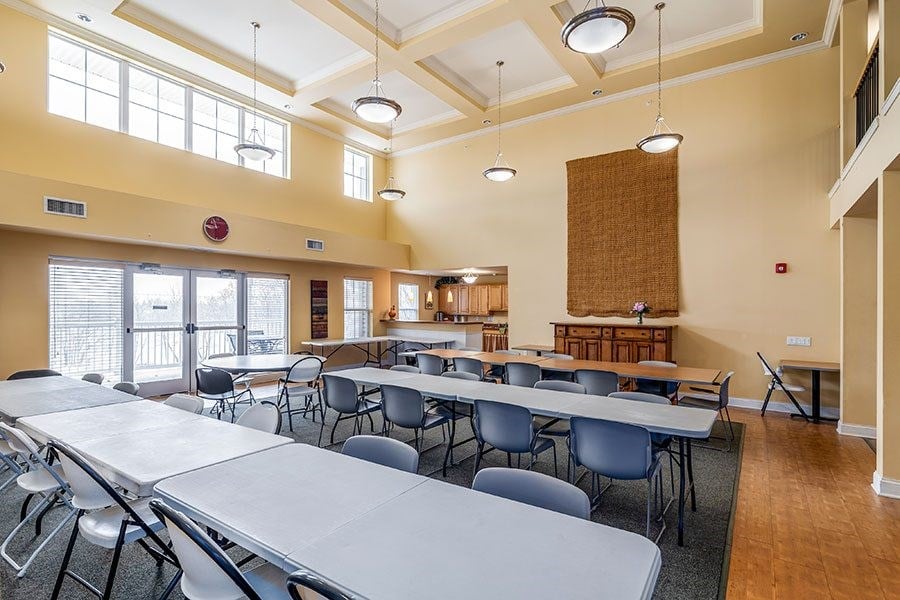 A large room with tables and chairs is empty.