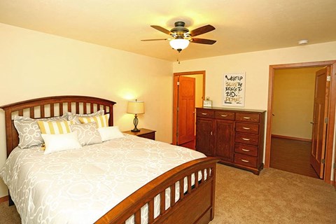 a bedroom with a bed and a ceiling fan