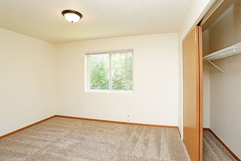 A room with a carpeted floor and a window.