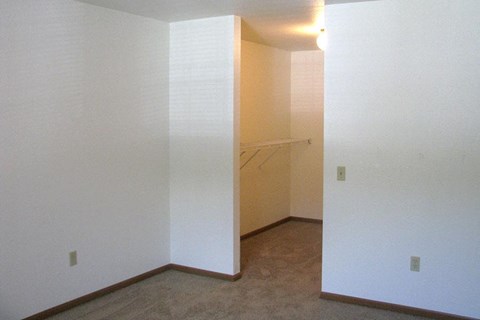 an empty room with white walls and a closet