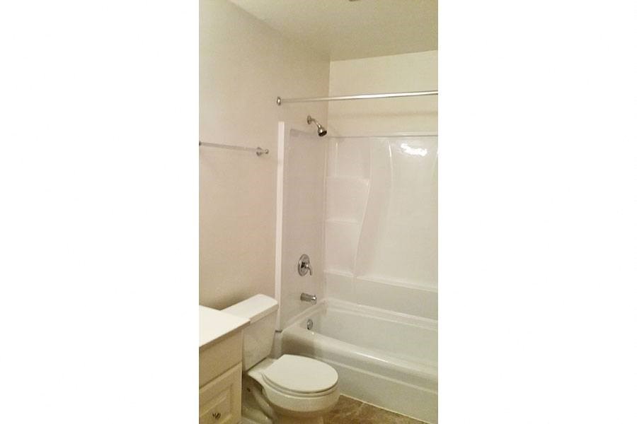 a bathroom with a toilet and a tub and a sink