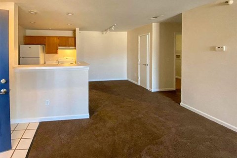 an empty room with a kitchen and a living room